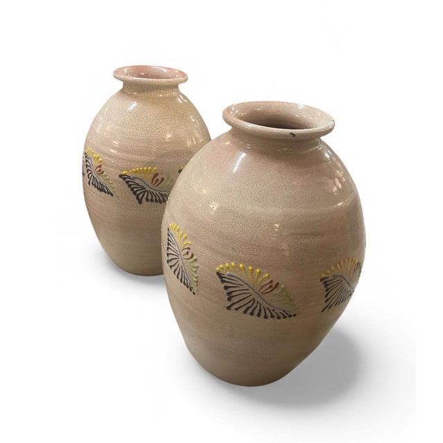 A pair of vintage ceramic vases with a rounded ovoid form, gently flared rims, and a soft neutral crackle glaze. Each is...