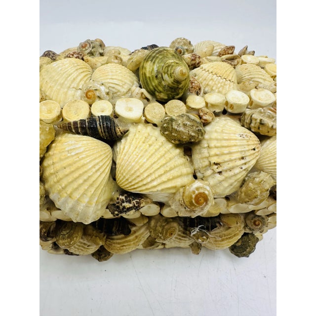 This is a decorative rectangular shell box, crafted by hand with a variety of natural seashells. The surface is completely...
