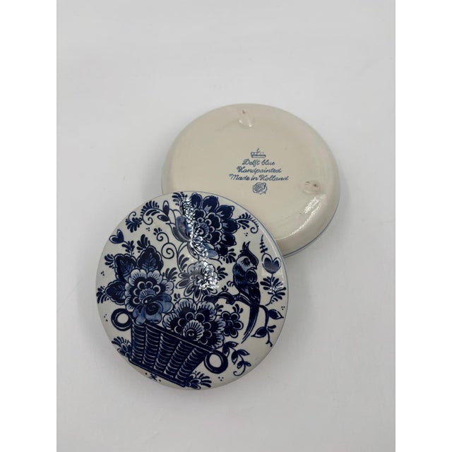Beautiful round Delft ceramic box, hand-painted in classic blue and white with a richly decorated floral/basketry motif on...