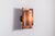 This vintage Danish wall lamp is distinguished by its sculptural composition of two opposing, shield-like copper elements...