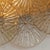 This large wall or ceiling light is composed of several circular discs with a striated texture and an amber hue, creating...