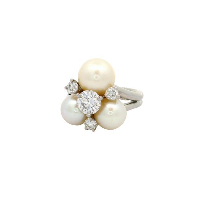 A contemporary platinum cluster ring featuring lustrous white pearls and sparkling diamonds. The design showcases three...