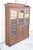 Antique Eastlake Victorian Walnut Wavy Glass Triple Bookcase Display Cabinet. Item features 16 adjustable wooden shelves...