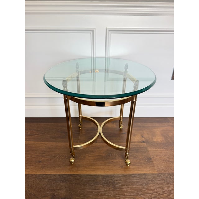 A sophisticated vintage brass and beveled glass side table executed in the iconic style of LaBarge, featuring a sculptural...