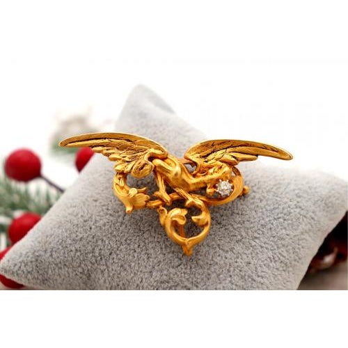 Gold brooch/medal in the shape of a bird with reliefs and applications with old brilliant cut diamonds. Metal: Gold....