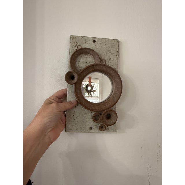 A striking hand-built studio pottery wall mirror, signed by the artist Henrick on the reverse (as shown). This sculptural...