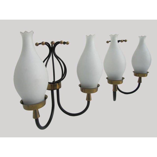Pair of wall sconces with white satinized opaline glass shades, black lacquered metal and brass, Italy 1950s These sconces...