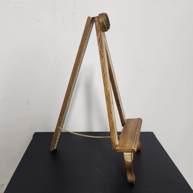 A vintage Italian Florentine-style tabletop easel, beautifully finished in distressed cream with gilt gold accents. The...