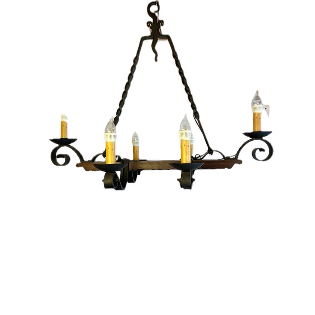 Spanish style hand wrought chandelier with 6 arm lights and wood base. Perfect for an arts and crafts style house.