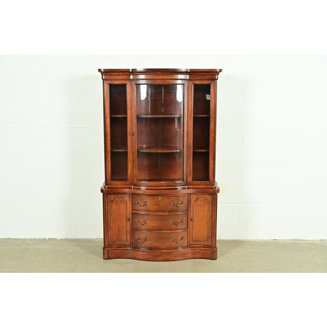 A gorgeous bow front Georgian or Chippendale style breakfront bookcase or dining cabinet In the manner of Baker Furniture...