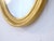 This pair of giltwood oval mirrors have a rubbed gold finish.