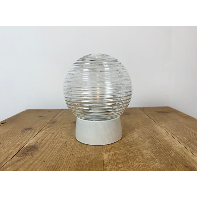 Vintage industrial ceiling or wall light made in former Czechoslivakia during the 1970s. It features a white porcelain...