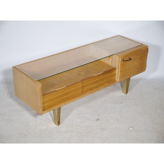 Vintage lowboard with gold-colored hairpin legs, made in Germany in the 1960s. Asymmetrical design with a glass top, two...