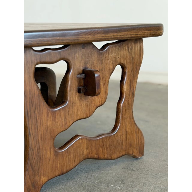 W40 D22.5 H18 This compact walnut stained, solid oak coffee table features an asymmetrical sculptural base with organic...