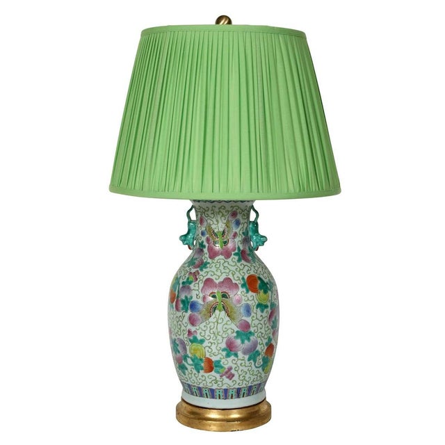 A striking pair of mid-20th-century Chinese Export porcelain lamps, richly decorated in the famille-rose palette with...