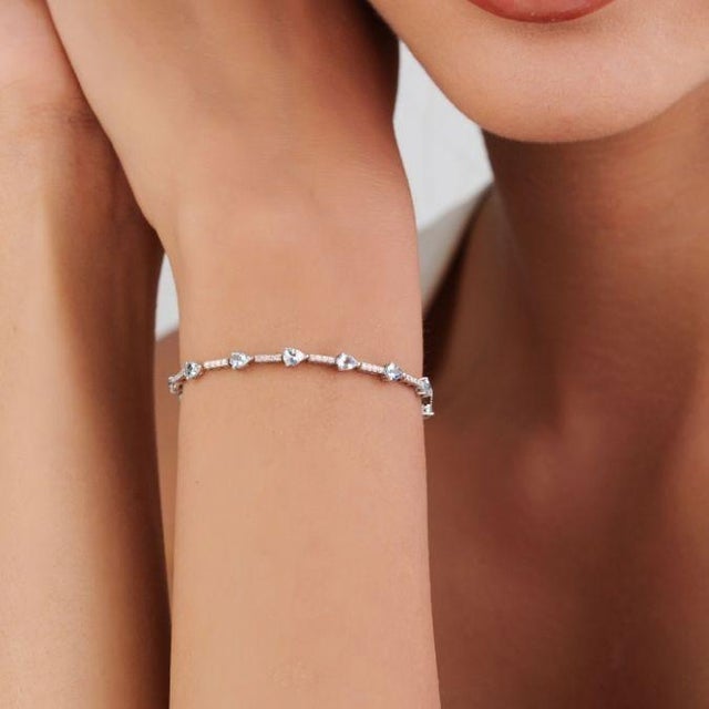 This modern tennis bracelet features 1.61 carats of aquamarine and diamond, set in 14k white gold. Each measuring...