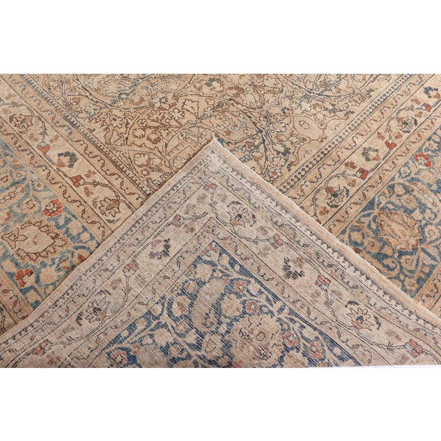 An early 20th century Persian Khorassan antique rug, the camel field with an allover trellis of palmettes, swirling...