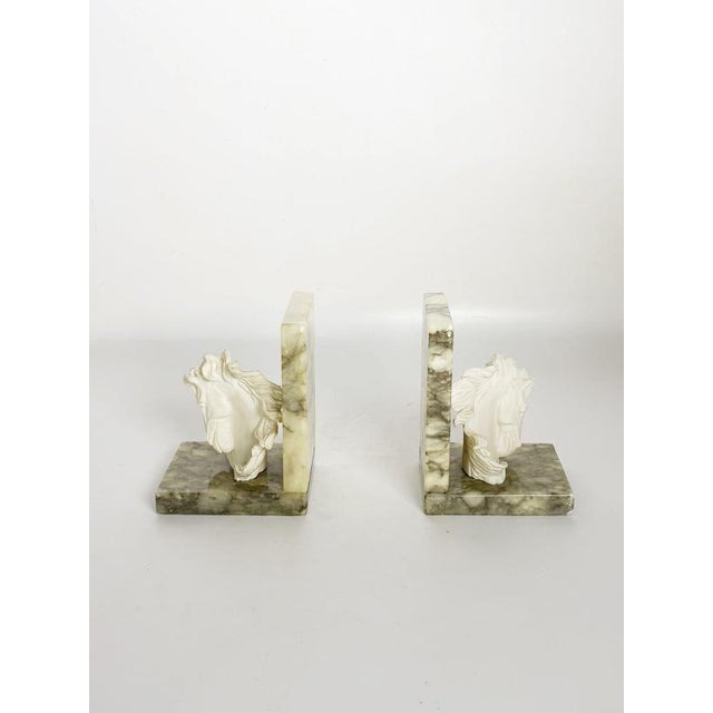 Decorative pair of French bookends dating from the 1970s, combining veined marble bases and supports with sculptural white...