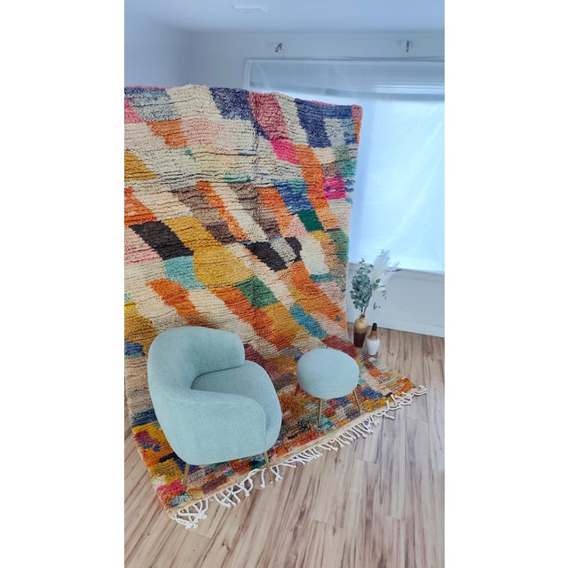 A vivid Boujaad patchwork on a cream ground — thick diagonal bands of orange, mustard, teal, forest green, navy, pink and...