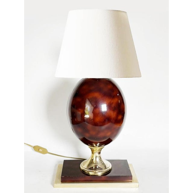 The lampshade is not included. A US adapter is provided. Burgundy table lamp with brass details, France, 1970s, with an...