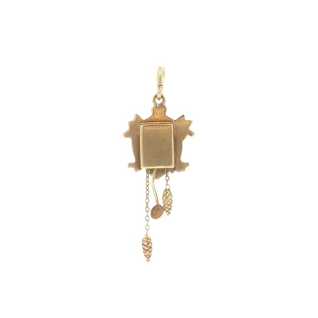 A vintage charm crafted from 14k gold. Features a detailed cuckoo clock design with pinecone weights. Measures 1.75 inches...