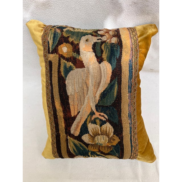 This decorative pillow is upholstered with an authentic 18th-century tapestry, showcasing a beautifully detailed bird...