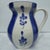 A beautifully hand-painted vintage Italian ceramic pitcher featuring a timeless blue-and-white palette with charming...