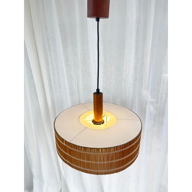 A beautifully designed pendant light, likely from the 1960s or 1970s, from denmark. hand-woven teak slats with a beautiful...