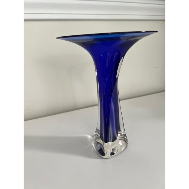 Crafted in 1991 by artist Winfisky, this exquisite signed studio art glass vase showcases a vibrant, deep cobalt blue core...