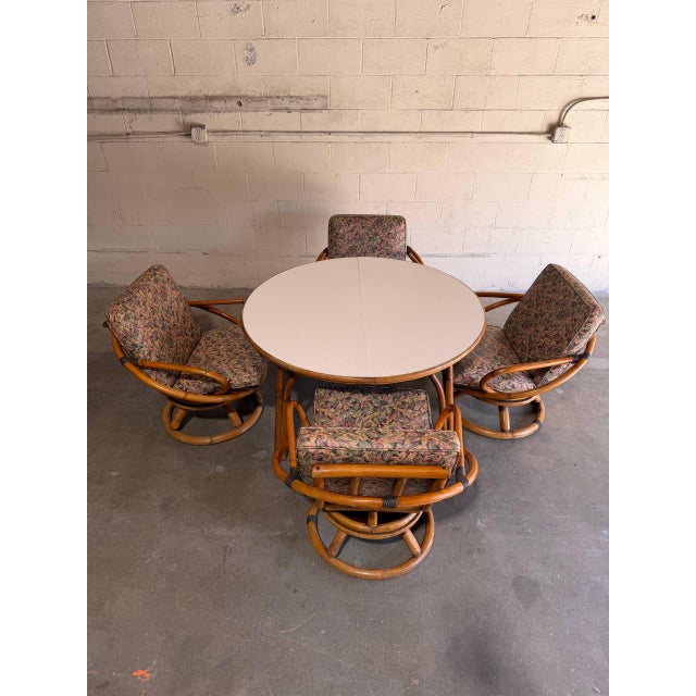 This vintage dining set features a round extension table paired with a matching set of 4 swivel chairs. The organically...