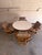 This vintage dining set features a round extension table paired with a matching set of 4 swivel chairs. The organically...