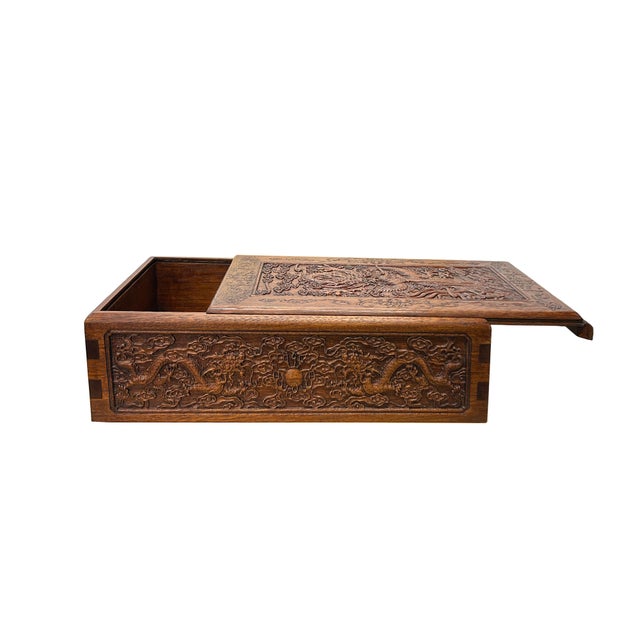 Crafted with intricate detail, this rectangular oriental box showcases the art of high-relief wood carving, featuring a...