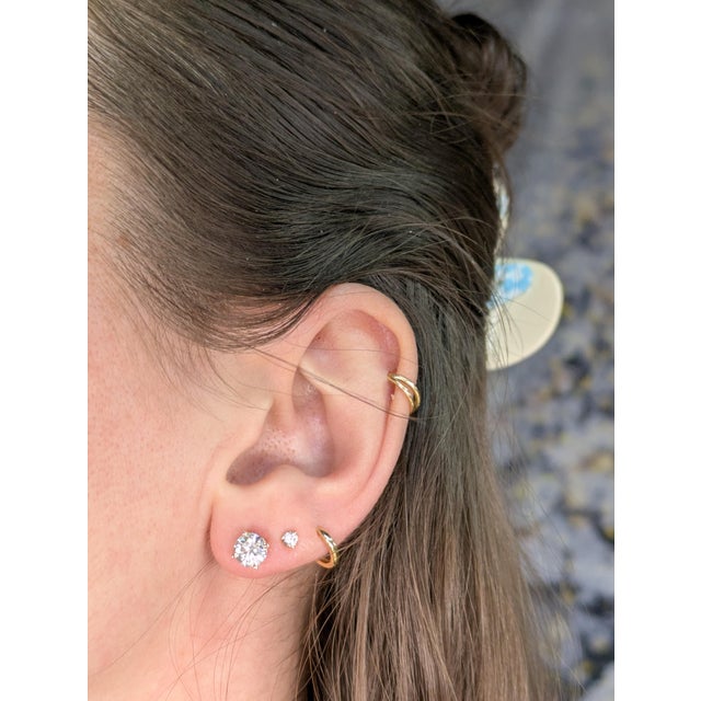 An elegant stud earrings featuring 14K yellow gold settings with lab-grown diamonds. Each earring is set with a 6mm round...