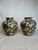 This pair of moderately sized glazed, ceramic ginger jars have a multi faceted design of floral, fruit and insects. The...