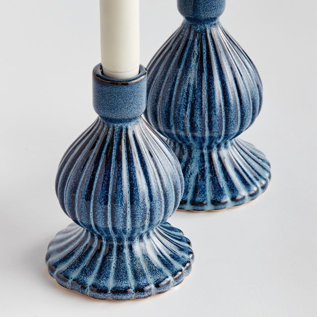 Made of a highfired, durable stoneware, a ribbed pattern and finished with a dynamic reactive glaze, these candle stands...
