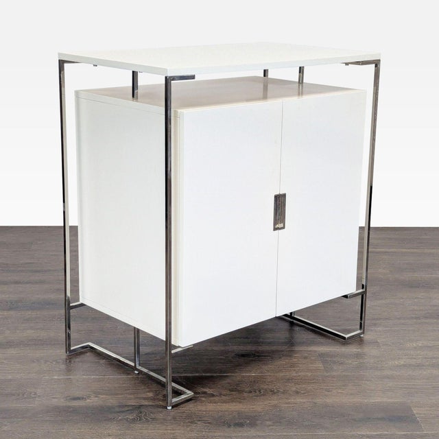 This West Elm cabinet features a clean white lacquer finish and a sleek chrome frame. Inside, it offers organized storage...
