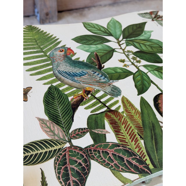 A charming vintage spindle side table, custom painted and finished with vibrant tropical decoupage featuring lush...