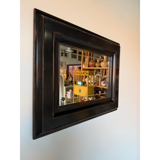 Elegant Baker for Milling Road wall mirror featuring a substantial black ebonized wood frame with layered stepped molding...