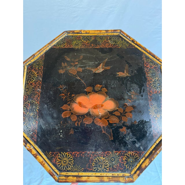 This is an antique English occasional table from the Aesthetic Movement, an octagonal black lacquered top on four...