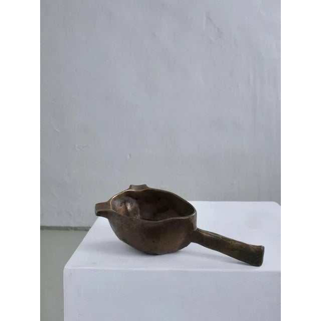 Brutalist ashtray cast in solid bronze with a sculptural, organic form. Features a short handle and two rest notches. Can...