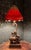 A striking Maitland Smith figural lamp, with a monkey perched atop an elaborately decorated elephant beneath a dramatic,...