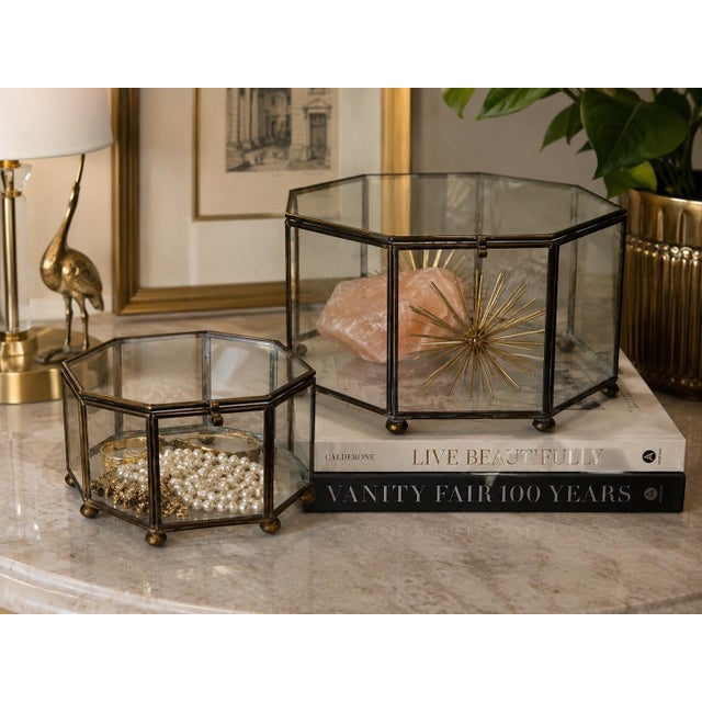 A beautiful vintage pair of handcrafted Mexican brass and glass display boxes featuring elegant octagonal forms and...