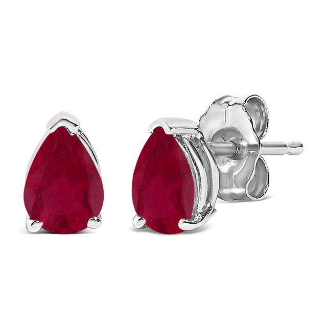 Envision the allure of glimmering ruby isles each time you adorn these exquisite solitaire stud earrings, featuring pear-...