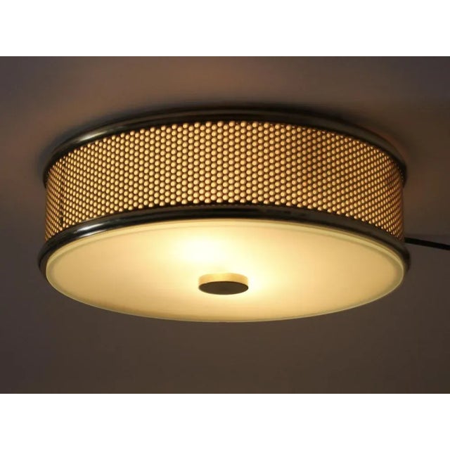 This very well-preserved circular lamp made of brass can be installed both as a wall and ceiling light. The lower cover is...