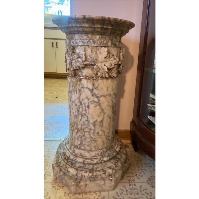 Beautiful Italian marble pedestal, dark veining throughout. Octagonal tiered base, cylindrical trunk and carved grapevine...