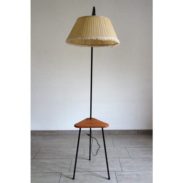 Tripod floor lamp with reading light, shelf, and integrated switch, dating from the 1950s/60s, France. Black metal base,...