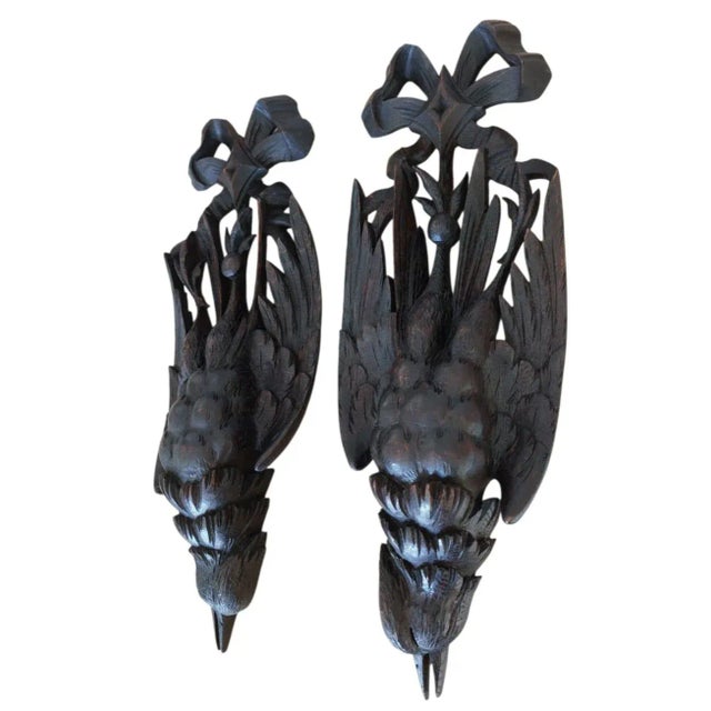 A stunning pair of antique Black Forest wall ornaments, masterfully hand-carved from solid walnut wood. Dating from the...