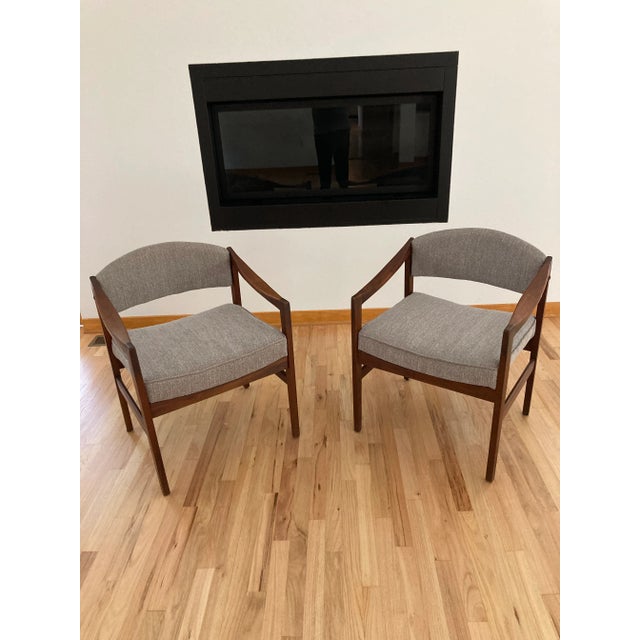 Mid Century pair of solid walnut side chairs in excellent condition. The chairs have been professionally reupholstered...