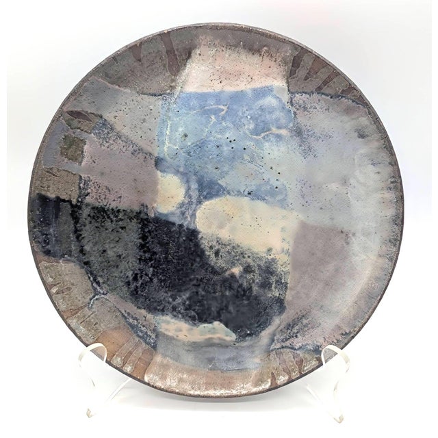 Offered is a studio pottery artisan-signed glazed stoneware decorative plate. The signature on the bottom reads: "PELE...