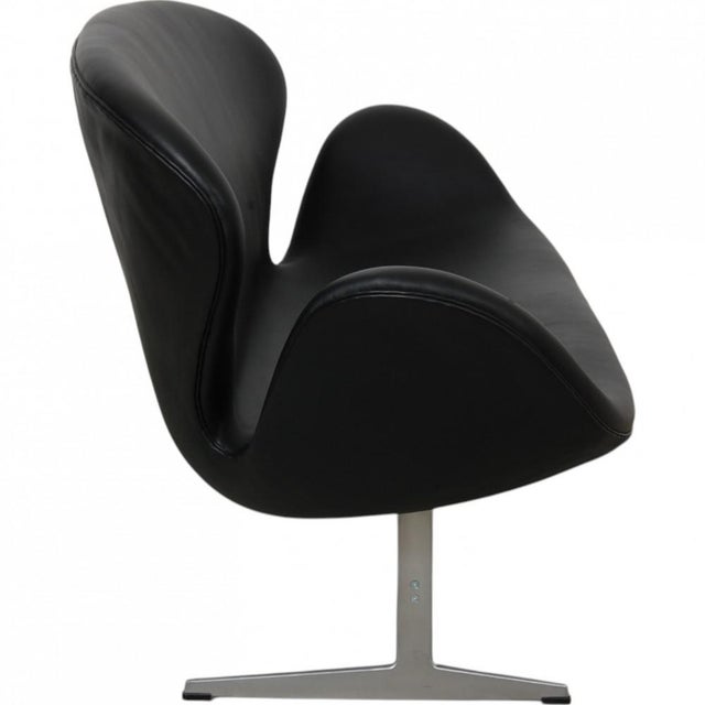 Arne Jacobsen Swan sofa upholstered in original black Aura leather from Fritz Hansen, and with a brushed aluminium base....